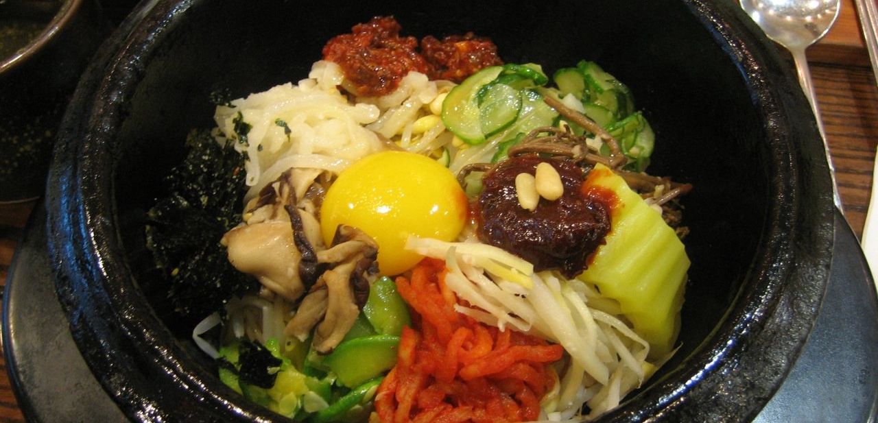 Dolsot bibimbap served in a hot stone bowl with vegetables and egg